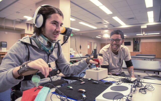 Person playing videogames with special accessible controllers